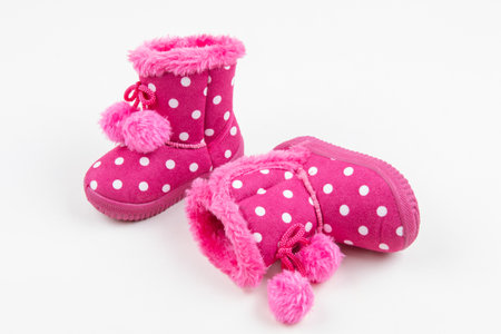 Adorable pink polka dot baby boots with faux fur trim and pom-poms. Cute, warm winter booties for a...