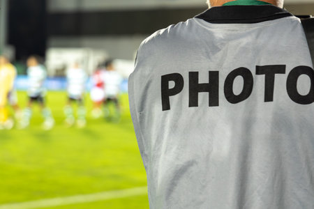 Photographer at football match.  Professional photographer shoots a soccer match at the stadiumの写真素材