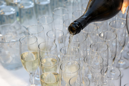 The waiter pours champagne in glasses. Wedding cateringの写真素材