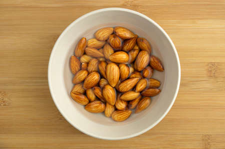 Activated almonds soaking in white bowlの写真素材