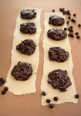 Tasty dark chocolate chip cookies on parchment baking paper.の写真素材