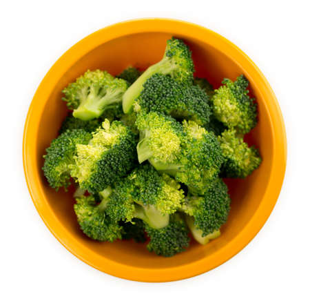Aerial view of freshly cut pieces of raw organic broccoli in a bowl isolated on a white background.の写真素材