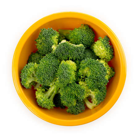 Raw pieces of broccoli florets in a bowl isolated on a white background.の写真素材