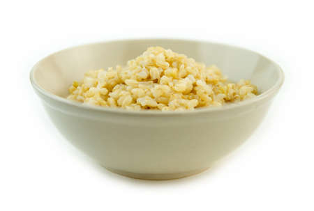 Isolated bowl with brown rice against whiteの写真素材