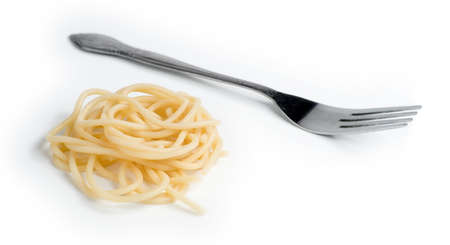 Macro of swirl of cooked spaghetti with fork isolated against whiteの写真素材