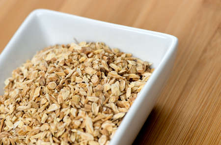Macro of astragalus root chips against a wooden boardの写真素材