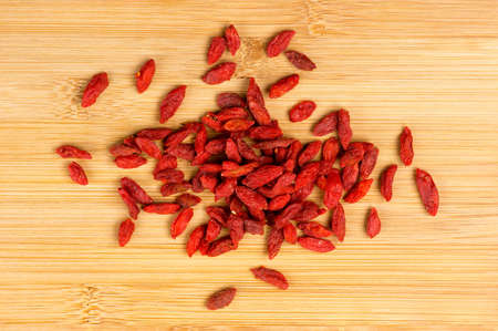 Pile of dry goji berries on a wooden boardの写真素材