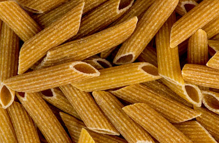 Macro closeup background texture of whole wheat rigatoni pastaの写真素材