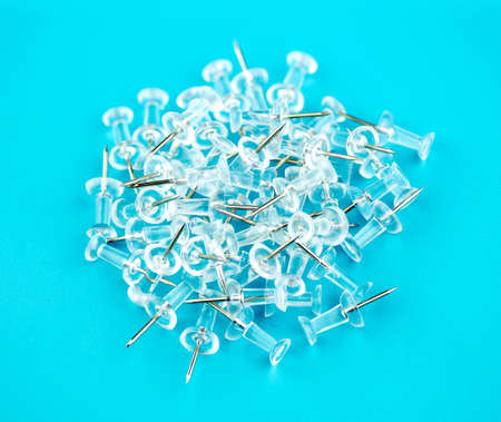 Pile of thumb tacks with colorful backgroundの写真素材