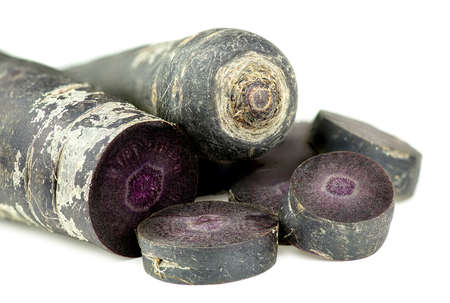 Cut up purple carrots isolated on white background textureの写真素材