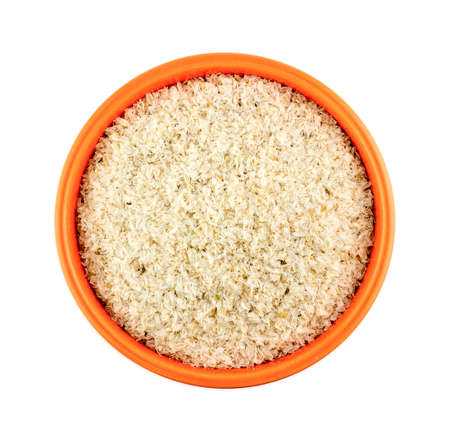 Orange bowl of psyllium husks isolated on white backgroundの写真素材