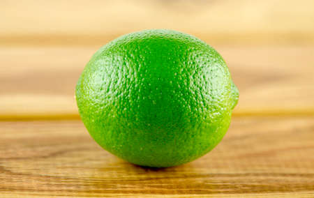 Macro closeup of delicious green lime against a rustic wooden background