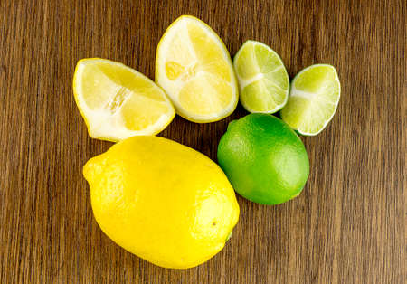 Overhead shot of vibrant ripe green limes and yellow lemons, cut and wholeの写真素材