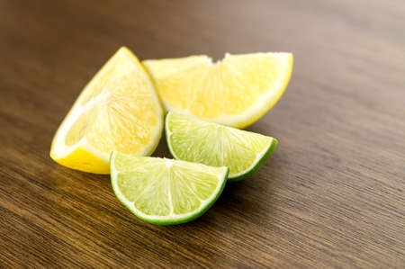 Juicy lemons and limes, cut and diced, on bar counter for drinksの写真素材