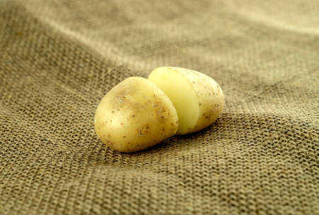 Perfectly cut in half potato on hessian farm sackの写真素材