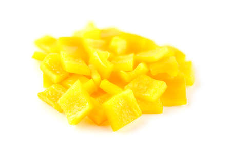 Crunchy cubes of diced yellow capsicum vegetable on whiteの写真素材