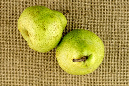 Ripe crispy green pears against hessian beckgroundの写真素材