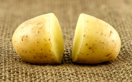 Macro of two halves of fresh potatoe on hessianの写真素材