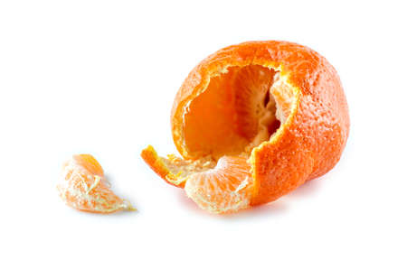 Mandarin with half peeled skin and pieces of citrus against whiteの写真素材