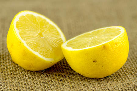 Closeup of lemon sliced in half against burlap clothの写真素材