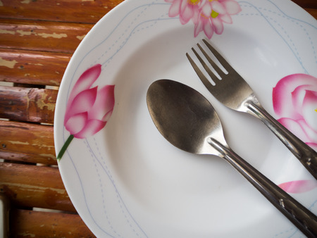 Table with empty plate and spoon and fork.の写真素材