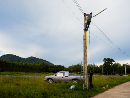 Electrician lineman repairing work on electric post power outdoor.のeditorial素材