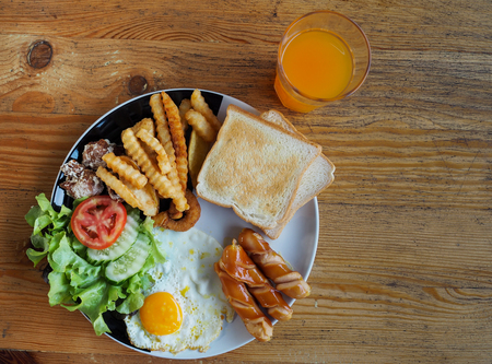 English breakfast with fried eggs, sausages,toasts and fresh salad.の写真素材
