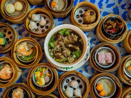 Traditional chinese dim sum steamed dumplings in the wooden plate on the table. dim sum chinese food in bamboo basketの写真素材