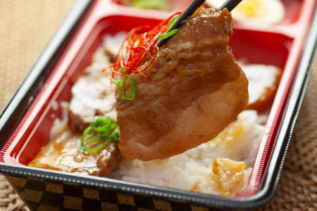 Pork bowls in a plastic container in a prepared bentoの写真素材
