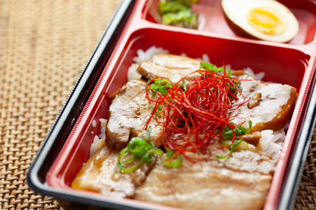 Pork bowls in a plastic container in a prepared bentoの写真素材