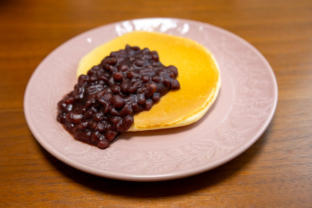 Pancake with red bean and butter on the wooden table.の写真素材
