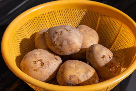 Potatoes in a plastic colanderの写真素材