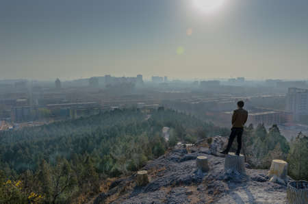 Man standing on the stump with haze around city