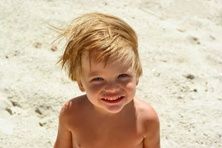 Young boy smiling on a sea beachの写真素材