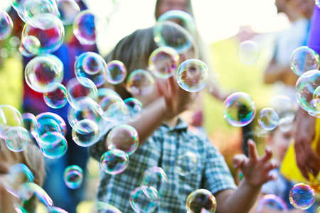 Baby boy among soap bubbles on a street showの写真素材