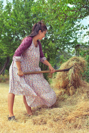 Girl in retro dress on agricultural operationsの写真素材