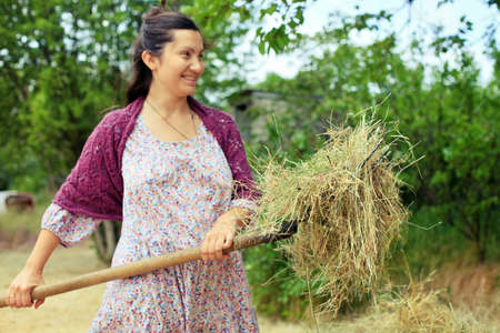 Girl in retro dress on agricultural operationsの写真素材