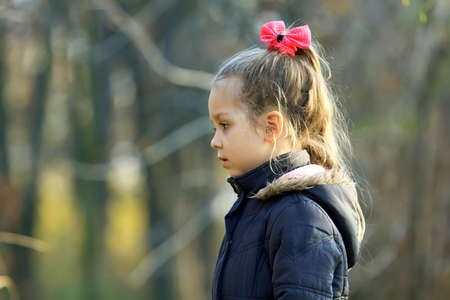 Thoughtful girl walks in autumn parkの写真素材