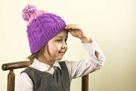 Pretty smiling girl in a woolen hat looks into the distanceの写真素材