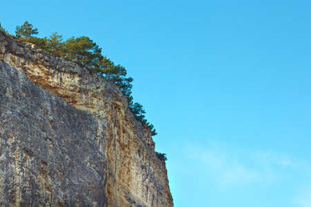 Mountain, a rock against the blue sky. In the foreground are growing bushes and grass. Gorizontal landscape.の写真素材