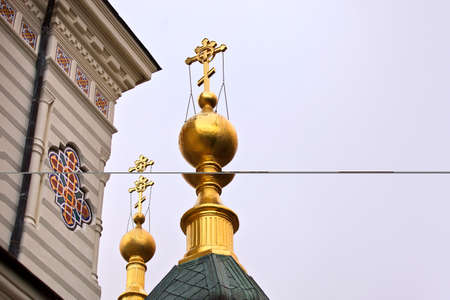 Gold crosses on kupoe black. The temple or church on a cloudy day. Gloomy skies. Rainy day. Details of the architectural ensemble. Taken from below. The religious building. Place of pilgrimage for Orthodox flock.の写真素材