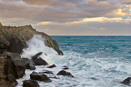 Marine pezazh. Horizon. A rock in the sea. Sea storm. The sea at sunset. The sky pink clouds. Foam waves beating against the rocks. At sea, windy sunny weather.の写真素材