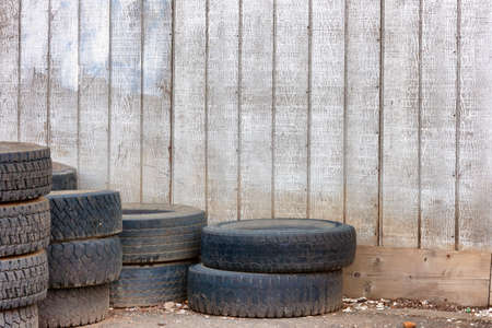 Junk tires stacked and left outside an old building.の写真素材