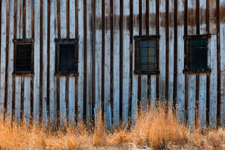 Steel bars cover windows on an old abandoned building.の写真素材