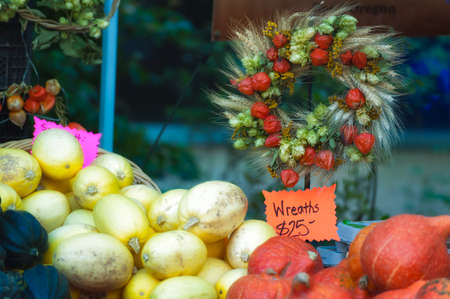 Farmers Market fall harvest of squash, their fall colors accented by a harvest wreath.の写真素材