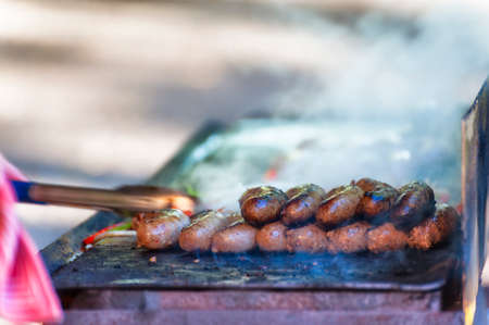 Sausages being grilled on a grill at Farmers Marketの写真素材