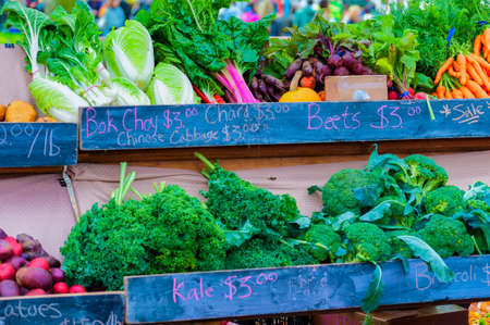 close up of vegetable display with strips of chalkboard with discription of vetables.の写真素材