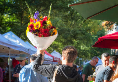 Portland, Oregon, USA - September 20, 2014: A man sales a bouquet of flowers at Portland Oregon's, south park block farmers market.のeditorial素材