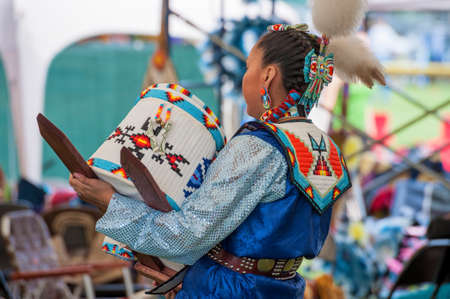 Portland, Oregon, USA - June, 14, 2014: A Native American Indian dances while holding a baby in a Papoose Cradleboard at the annual Delta Park Pow Wow in Portland, Oregonのeditorial素材