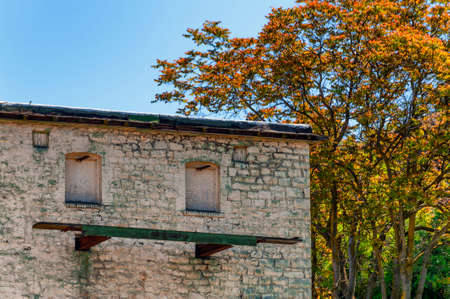 Windows boarded up and a steel and wood platform on the side of an old building.の写真素材
